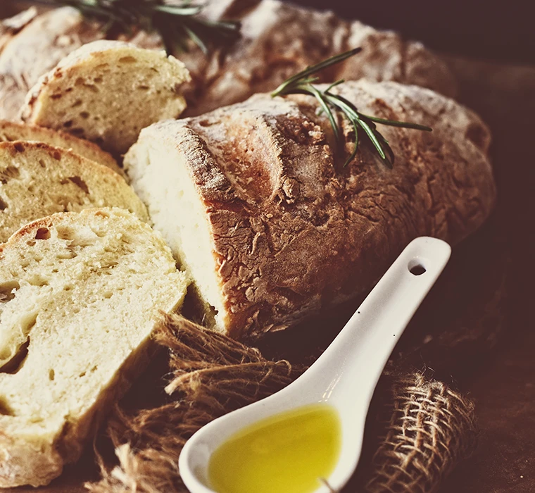 Frisch, in Scheiben geschnittenes Brot mit Olivenöl und Kräutern