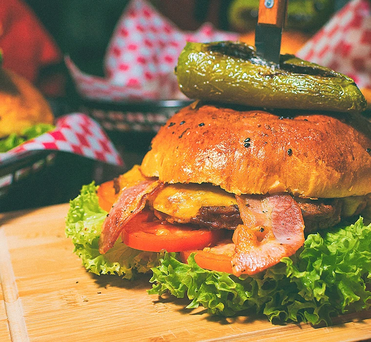 Saftiger Hamburger in einem Restaurant mit Bacoun, Fleisch, Tomaten und Salat beleg