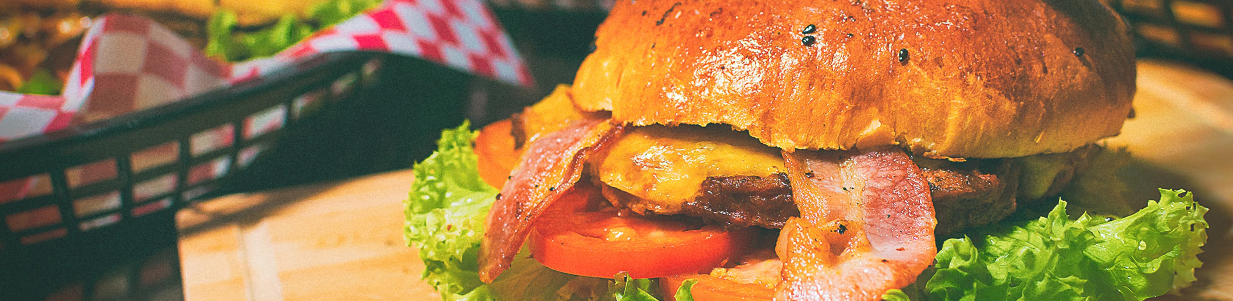 Saftiger Hamburger in einem Restaurant mit Bacoun, Fleisch, Tomaten und Salat belegt